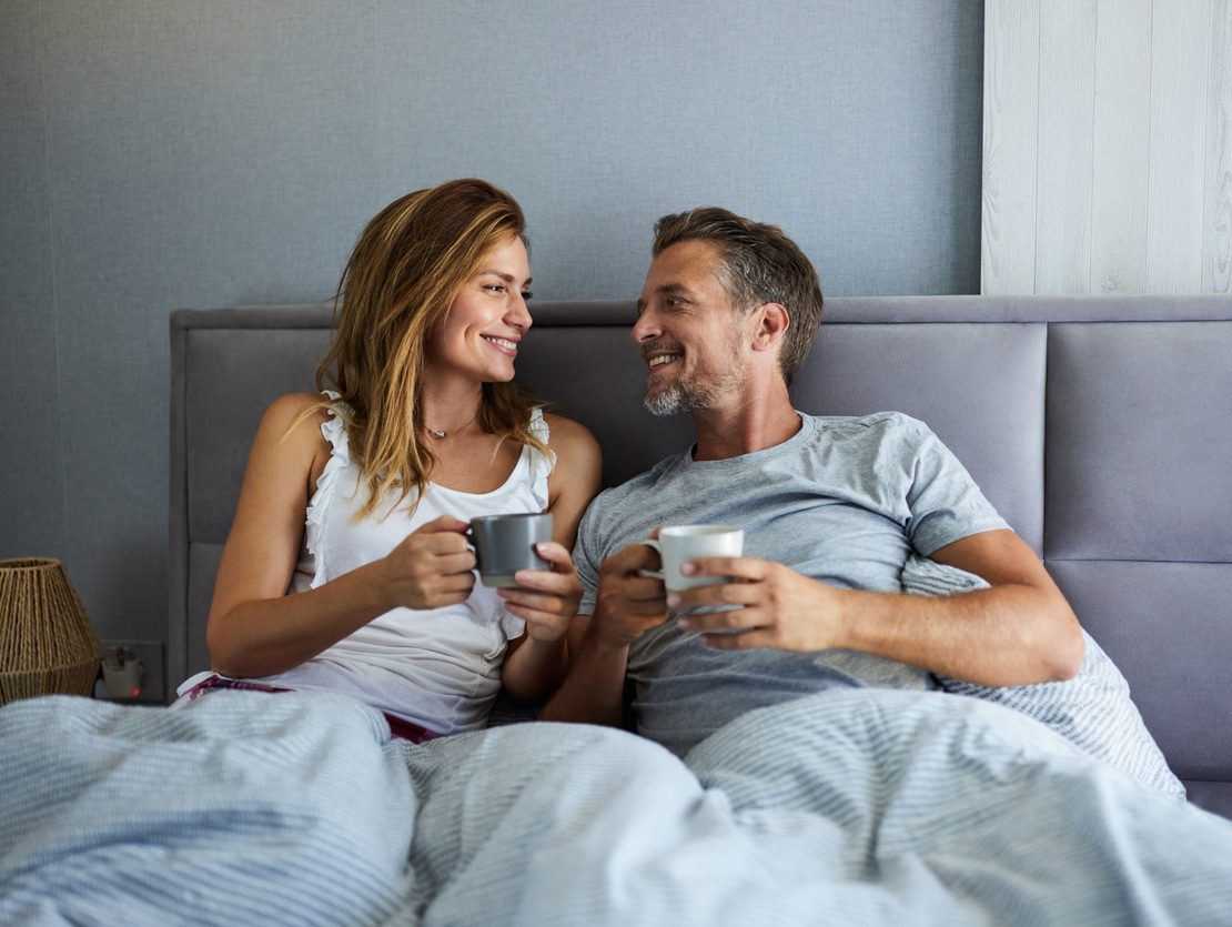 a man and a woman sitting on a bed